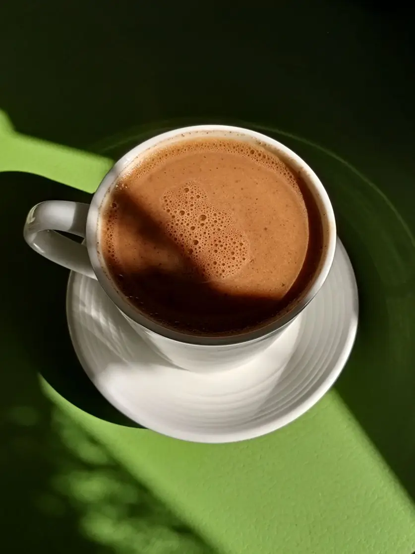 A cup of cocoa on a green surface